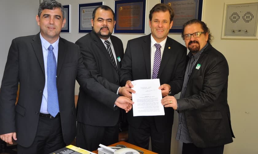 Dr. Jonas Moreno (Diretor de Assuntos para Refugiados e Ajuda Humanitária da ANAJURE), Dr. Uziel Santana (Presidente da ANAJURE), Deputado Federal Leonardo Quintão (Presidente da Frente Parlamentar Mista para Refugiados e Ajuda Humanitária da ANAJURE) e A