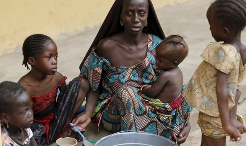 Mulher resgatada do Boko Haram alimenta um de seus filhos no campo de refugiados, na Nigéria.