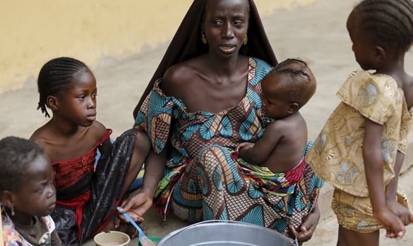 Mulher resgatada do Boko Haram alimenta um de seus filhos no campo de refugiados, na Nigéria. (Foto: Reuters/Afolabi Sotunde)