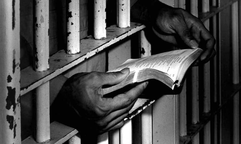 Homem lê a bíblia na prisão