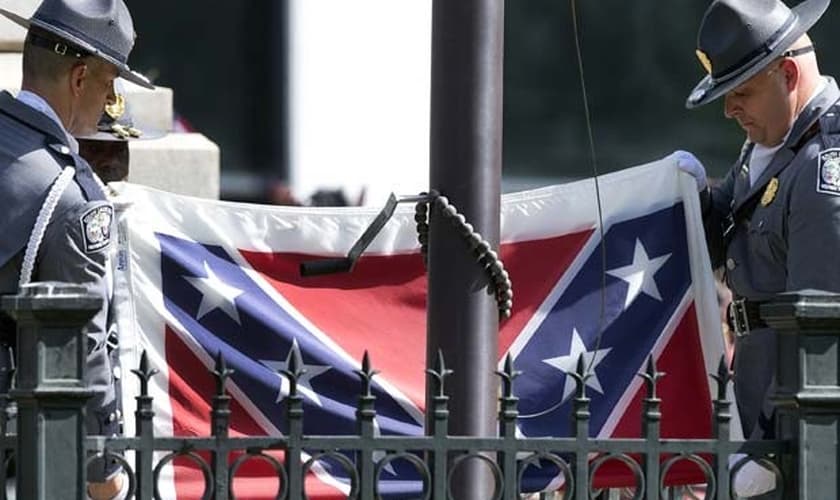 Guardas retiram bandeira confederada dos jardins do Capitólio. (AP Photo/John Bazemore)