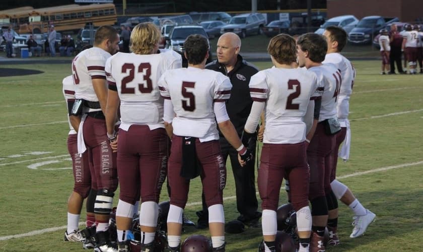 treinador do time de futebol americano da escola Chestatee se reúne com seus alunos / atletas momentos antes do jogo