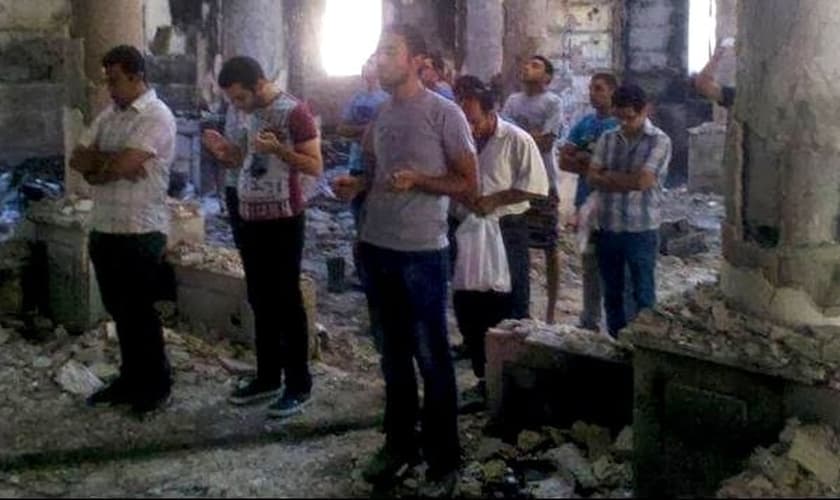 Cristãos oram dentro de templo em ruínas, na Síria.