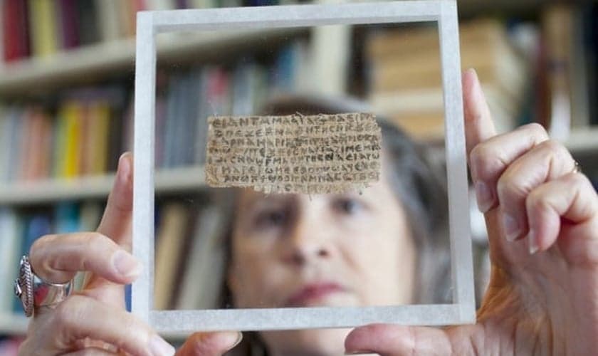 Karen King exibe o papiro com trecho do "Evangelho da Esposa de Jesus", desmascarado após revelação do antigo proprietário. (Foto: Harvard Magazine)