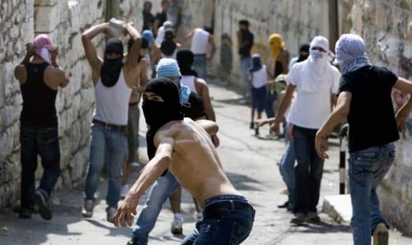 Jovens palestinos atiram pedras contra forças israelenses em Jerusalém (Foto: AFP)