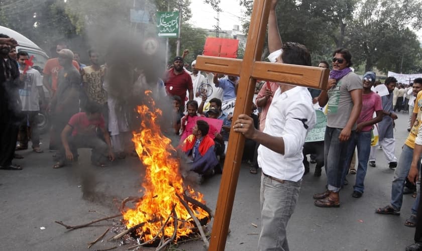 Membro da comunidade cristã paquistanesa segura uma cruz durante um protesto para condenar ataques contra igrejas. (Foto: Reuters/Mohsin Raza)
