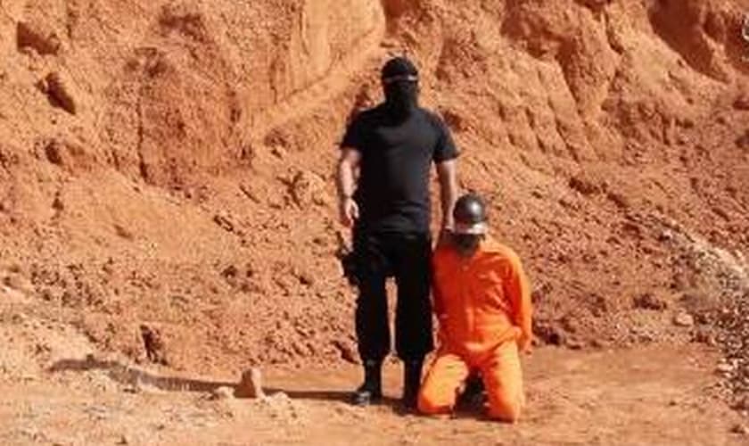 Na imagem, o terrorista envia uma mensagem ameaçadora aos cristãos e depois força a vítima a se ajoelhar para ser degolada. (captura de tela)