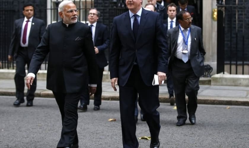 Primeiro-ministro Modi caminha ao lado de David Cameron, e meio a protestos de manifestantes enfurecidos (Foto: Reuters)