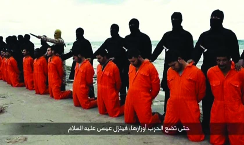 Militantes do Estado Islâmico se posicionam atrás de 21 cristãos coptas, momentos antes de registrarem a execução destes, que barbarizou o mundo em fevereiro de 2014 (Imagem: Reprodução)