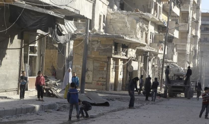 Moradores perto de edifícios danificados na vila de Kafr Hamra, no norte rural de Aleppo, Síria (27 de fevereiro de 2016). Foto: Reuters.