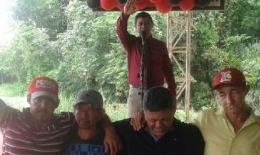 Pastor João Bispo ora pelos necessitados, enquanto os recebe em sua festa de aniversário. (Foto: Reprodução)