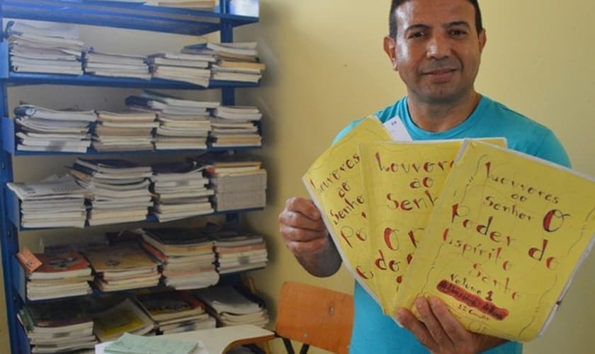 Detento com mostra as histórias que escreveu em sua coletânea. (Foto: Divulgação/Sejus)