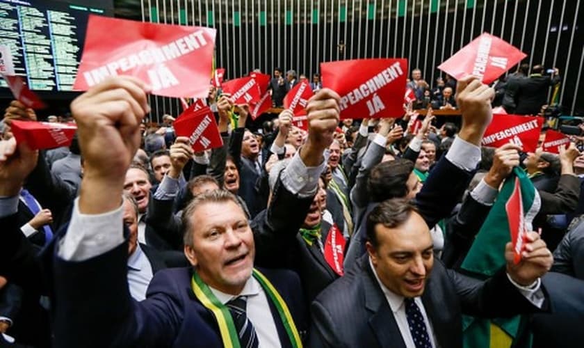 Deputados exibem cartões com a frase "impeachment já" no Plenário da Câmara. (Foto: Folha.com)