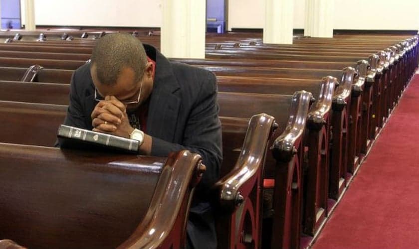 Pastor ora sozinho em igreja. (Foto: Olisa)