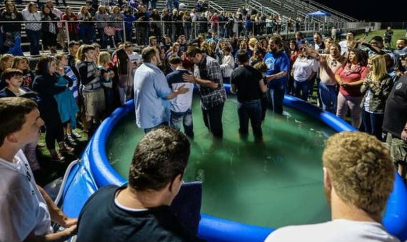 Estudantes sendo batizados em pscina inflável na escola. (Foto: Wes Wilson Photography).