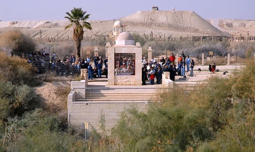 Um grupo de peregrinos na Cisjordânia visualizam o local do batismo de Jesus, enquanto cercas os mantêm fora da zona de minas. (Foto: Alamy Stock Photo)