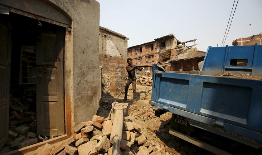 Homem revira escombros após terremoto no Nepal. (Foto: Reuters)