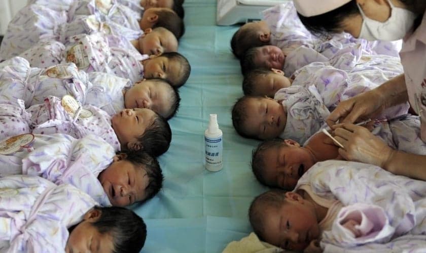 Bebês são cuidados por enfermeira na China. (Foto: South China Morning Post)