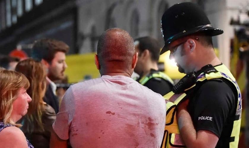Feridos pelo ataque são atendidos por policial em Londres. (Foto: Reuters)