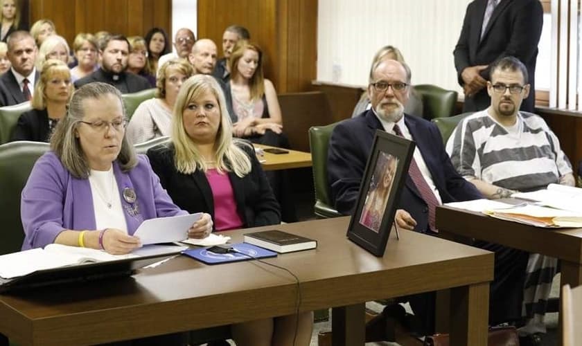 Leanda Bruck (esquerda) lê carta, enquanto repassa Bíblia a Clay Daniel (à direita). (Foto: Toledo Blade)