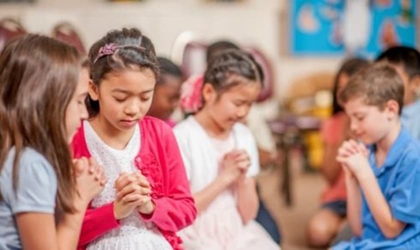 Crianças participam de momento de oração em escola. (Foto: Cedar Brook School)