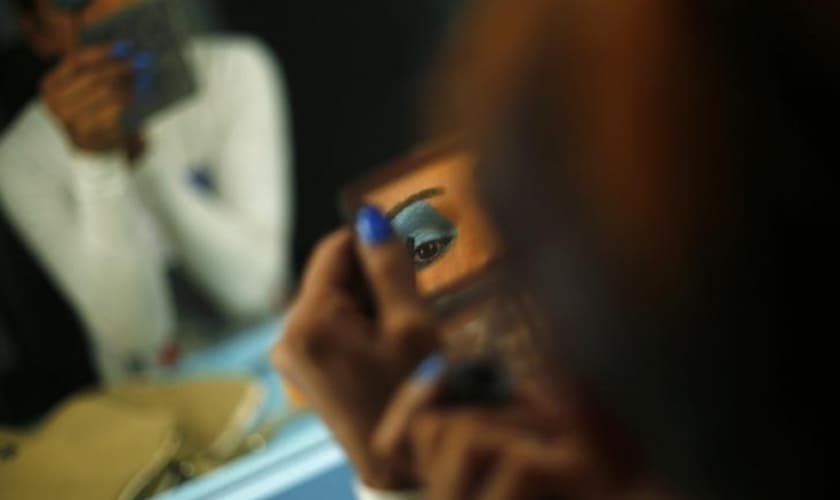 Modelo transexual se maquia antes de se apresentar em Nova Deli, na Índia. (Foto: Reuters/Adnan Abidi)