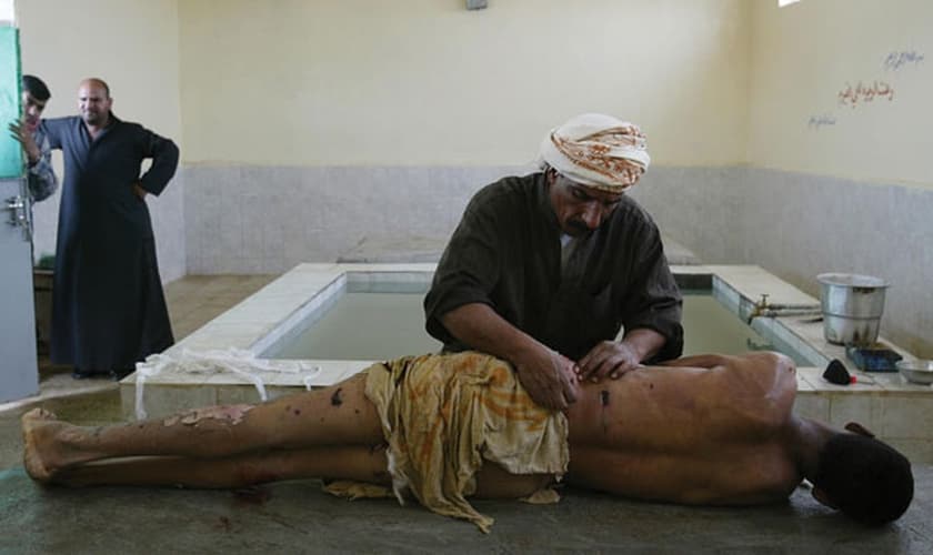 Imagem ilustrativa. Homem preparando o corpo para um enterro muçulmano em Najaf, no Iraque. (Foto: João Silva/The New York Times)