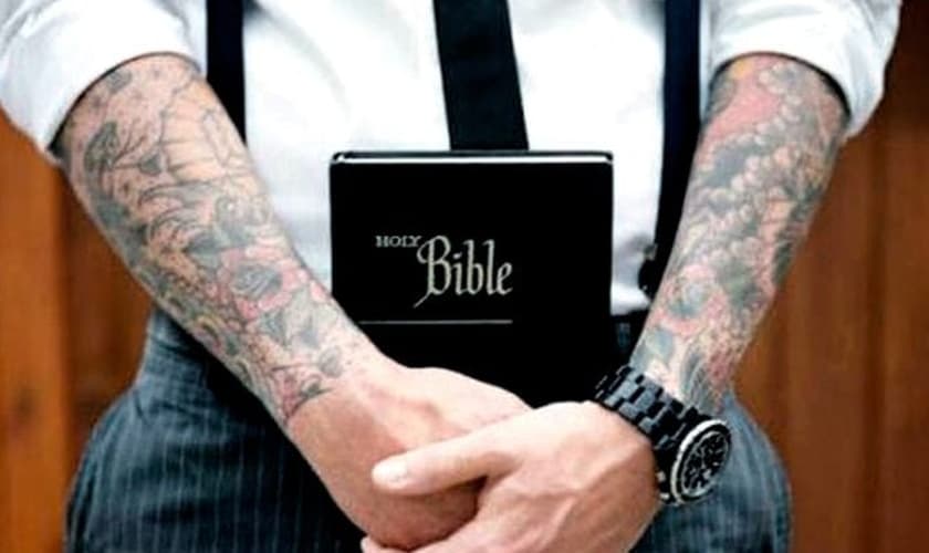 Braços tatuados seguram Bíblia. (Foto: cinconoticias.com)