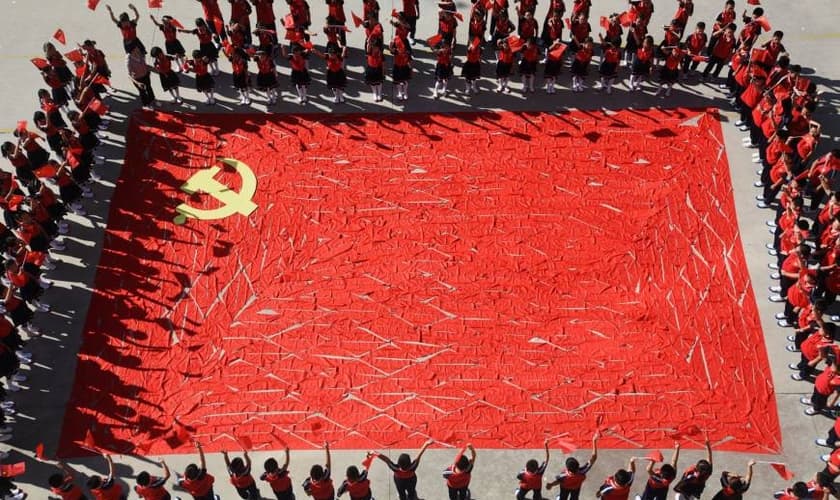 Estudantes ao redor de uma bandeira do Partido Comunista Chinês, na província de Shandong. (Foto: Reuters)