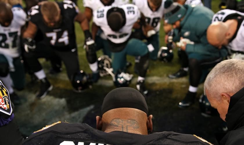 Steve Smith orando com jogadores da Philadelphia Eagles em Baltimore, Maryland. (Foto: Patrick Smith/Getty Images)