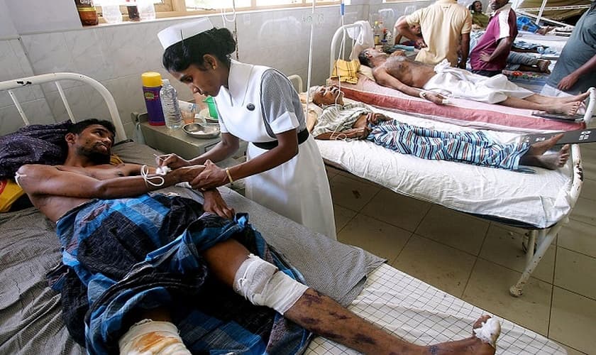 Imagem ilustrativa. Enfermeira cuida de homem enfermo em hospital, na Índia. (Foto: Reprodução)