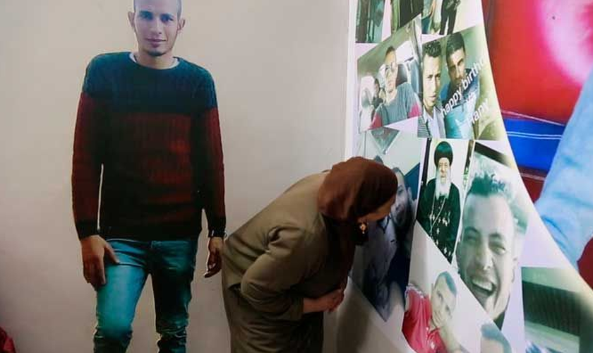 Quando tem saudades, Hanan visita uma parede cheia de fotos do filho. (Foto: Reprodução).