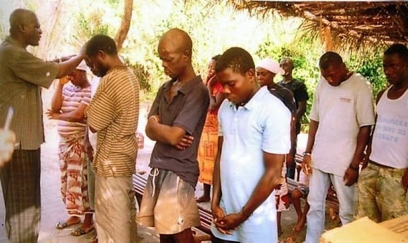 Pastor James Cuffee ora antes de batizar ex-feiticeiros na Libéria. (Foto: CHRISTIAN AID MISSION)
