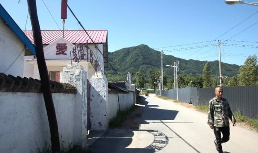 Chinês caminha em frente a uma igreja na fronteira com a Coreia do Norte. (Foto: Ng Han Guan/AP)