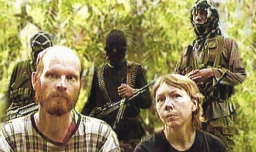 Martin (à direita) e Gracia Burnham (esquerda) com terroristas do Abu Sayaff ao fundo. (Foto: Persecution Blog)