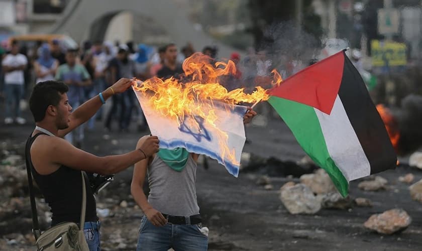 Palestino queima bandeira de Israel em protesto. (Foto: Sputnik International)