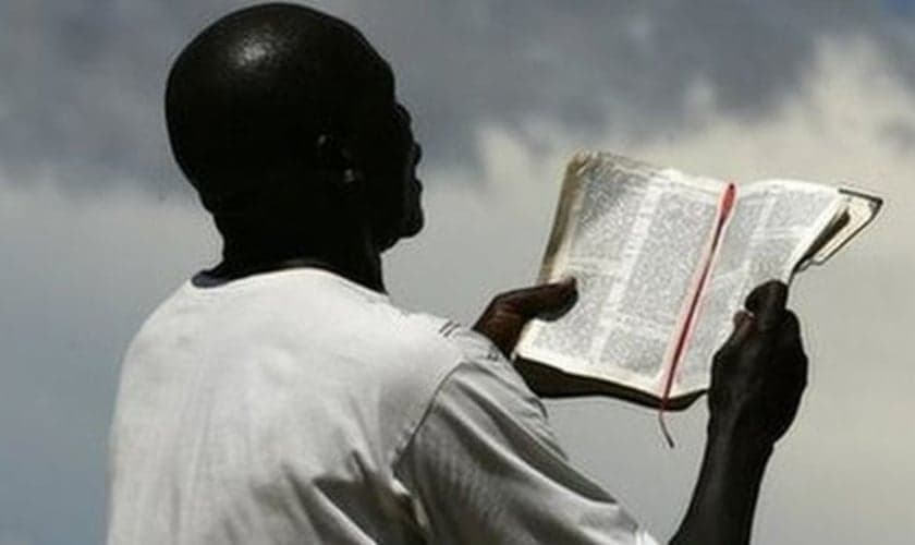 Imagem ilustrativa. Homem lendo a Bíblia Sagrada em país da África. (Foto: AFP)