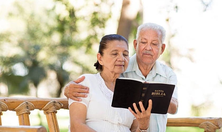 Imagem ilustrativa. Casal de idosos lendo a Bíblia Sagrada juntos. (Foto: Aldo Murillo/Captura/iStock)