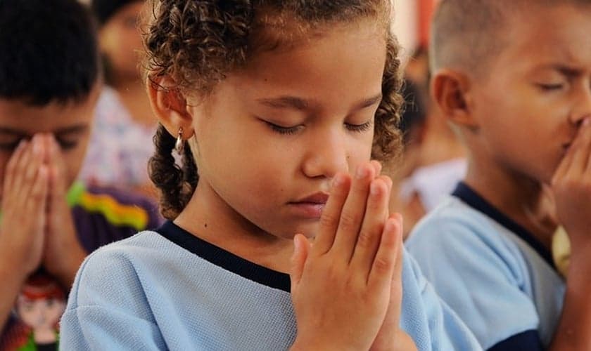 Crianças participam de momento de oração em escola. (Foto: Compassion)