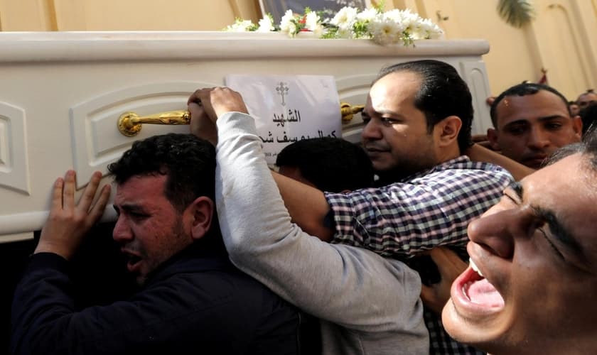 Homens carregam um caixão durante o funeral de cristãos coptas que foram mortos em ataque no Egito. (Foto: Reuters)