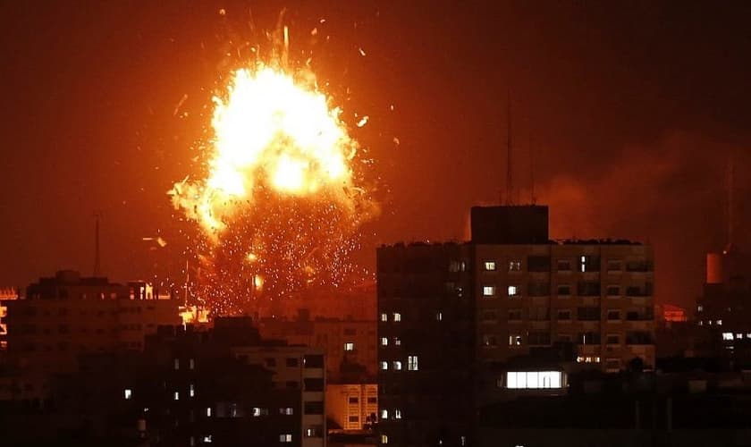 Bola de fogo sobre o prédio que abriga a TV Al-Aqsa, controlada pelo Hamas, na Faixa de Gaza. (Foto: Mahmud Hams/AFP)