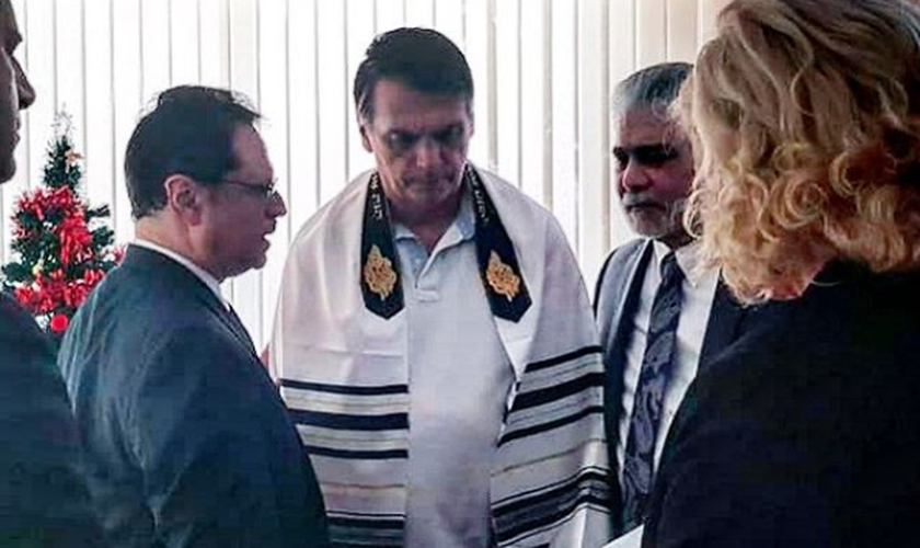 Usando um talit judaico, o presidente eleito Jair Bolsonaro recebe oração do pastor Mario Bramnick. (Foto: Reprodução/Instagram)