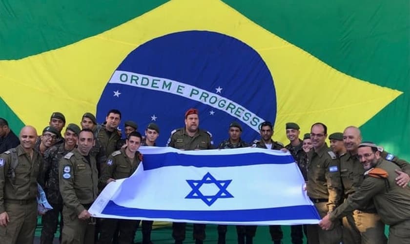 Soldados posam com a bandeira de Israel, com a do Brasil ao fundo. (Foto: David Atar/Embaixada de Israel)