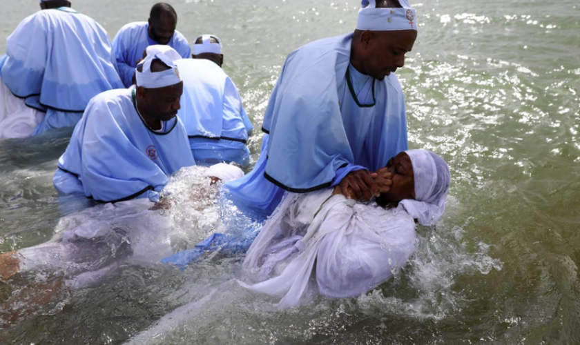 Os membros da igreja de Muchinjikwa são batizados na praia de Southend. (Foto: Reprodução/Reuters).