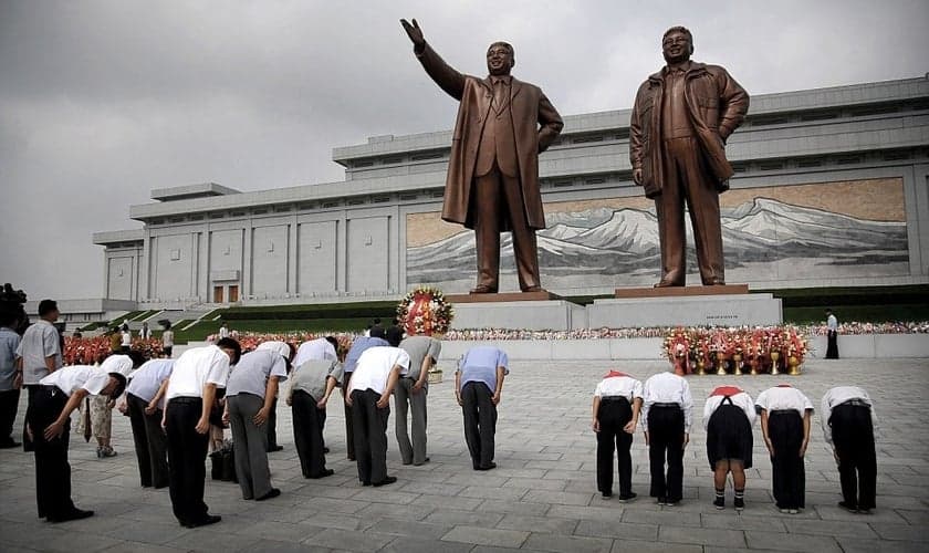 Norte-coreanos curvam-se diante das estátuas de bronze dos falecidos líderes Kim Il Sung e Kim Jong Il no Grande Monumento da Colina Mansu. (Foto: AP)
