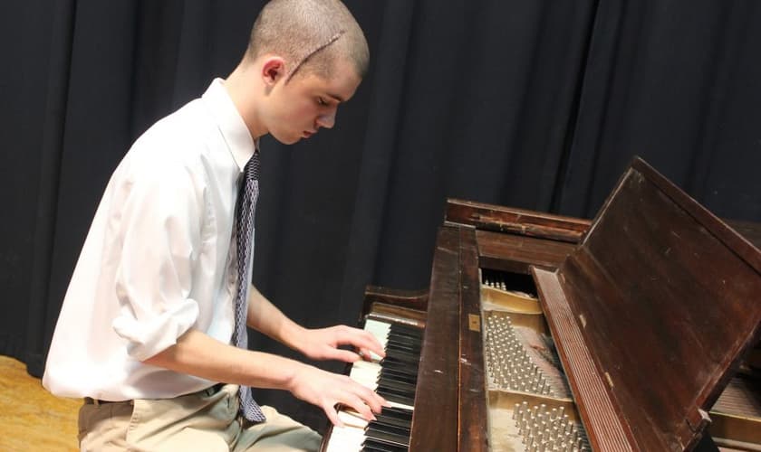 Dallin Rehl, 18 anos, toca “Odyssey” sua composição pessoal, em um piano na sexta-feira, uma semana depois de cirurgia no cérebro. (Foto: Janelle Patterson/Marietta)