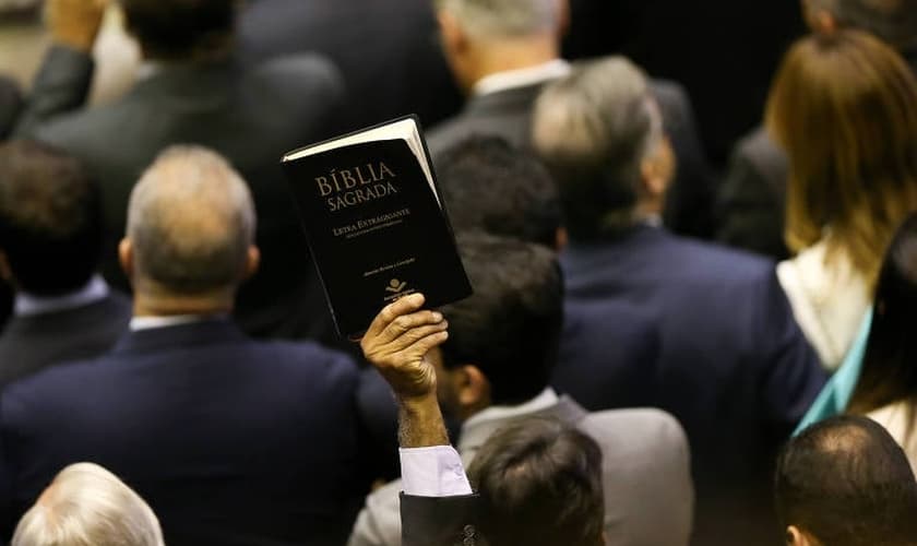 Deputado Pastor Sargento Isidório ergue Bíblia durante sessão solene de abertura dos trabalhos do Congresso. (Foto: Pedro Ladeira/Folhapress)