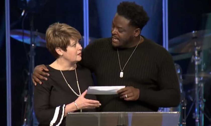 O pastor Derwin Gray entrega doação para Julie Walters, do Centro de Enriquecimento das Mulheres. (Foto: Reprodução/Facebook)