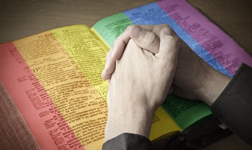 Imagem ilustrativa: Edição mostra homem repousando as mãos sobre Bíblia com páginas coloridas. (Imagem: Salon)