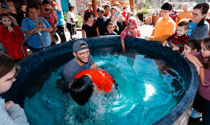 O pastor de jovens, Craig Blaylock, batiza membro da igreja que foi atingida por um tornado. (Foto: AP/Rogelio V. Solis)